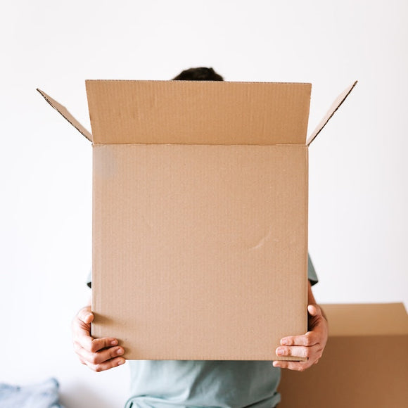 Person holding a large corrugated box.