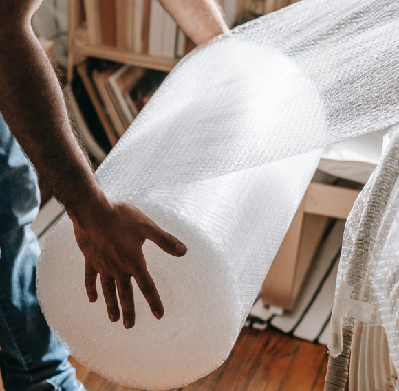 Man holding a roll of bubble wrap 